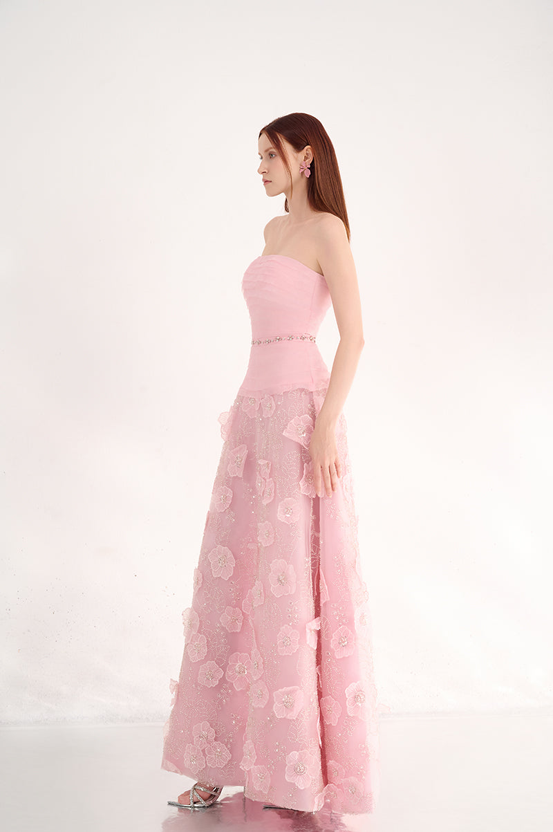 Pink strapless gown with floral details by Happy Clothing, featuring a flowing fabric and elegant design.