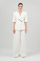 Izakova Tessa white pants displayed on a hanger, showcasing their sleek, tailored fit and clean design.