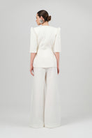 White Tessa pants by Izakova, shown on a model, featuring a tailored fit and sleek design perfect for casual or dressy looks.