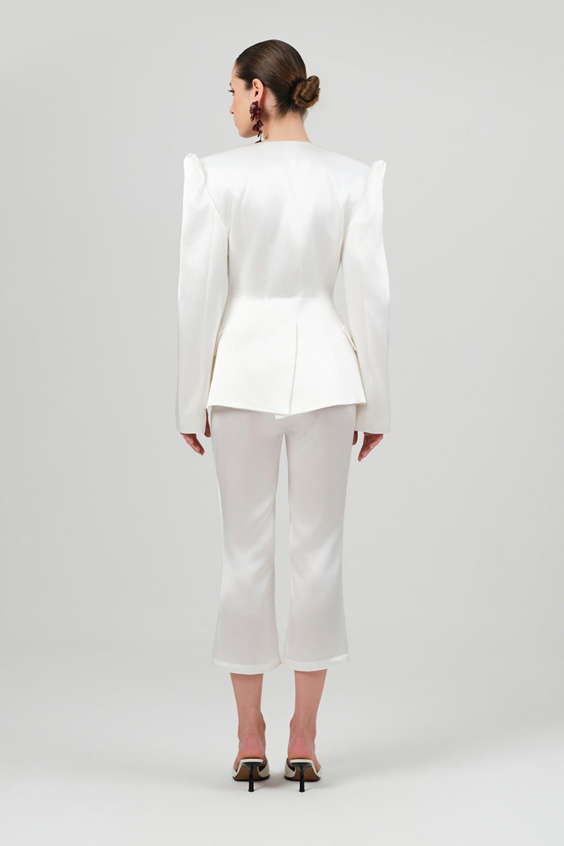 White satin REA pants from Izakova, stylish blazer with smooth fabric and tailored fit, displayed on a hanger.