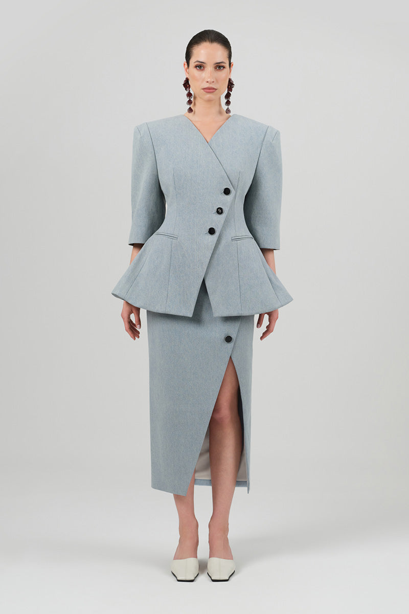 Izakova NEDA washed blue midi skirt with a flowing, A-line silhouette and subtle distressed details, shown on a hanger.