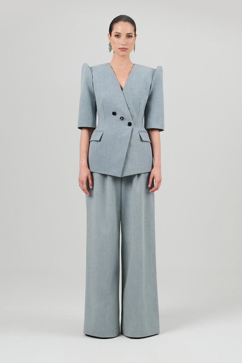 Izakova Tessa pants in washed blue, casual pants with a relaxed fit and denim texture, shown on a model.
