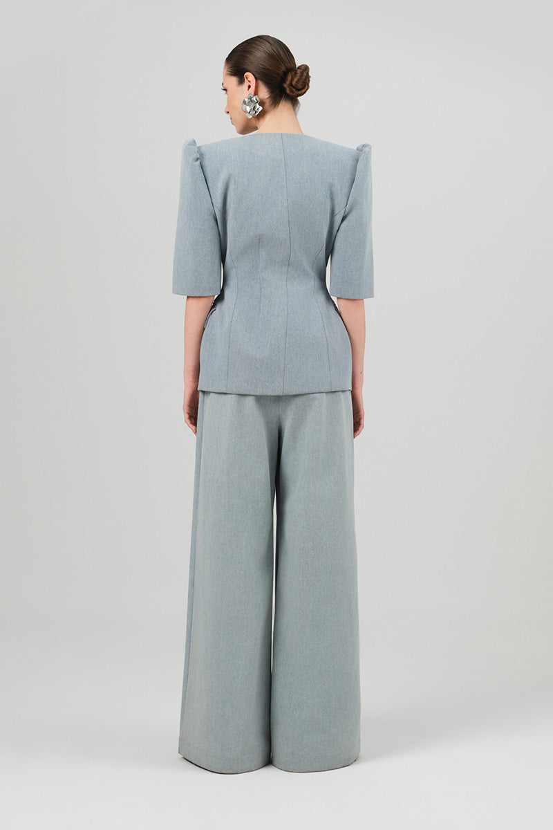 Izakova Bura blazer in washed blue, tailored fit with classic lapel, displayed on a hanger with a casual style.