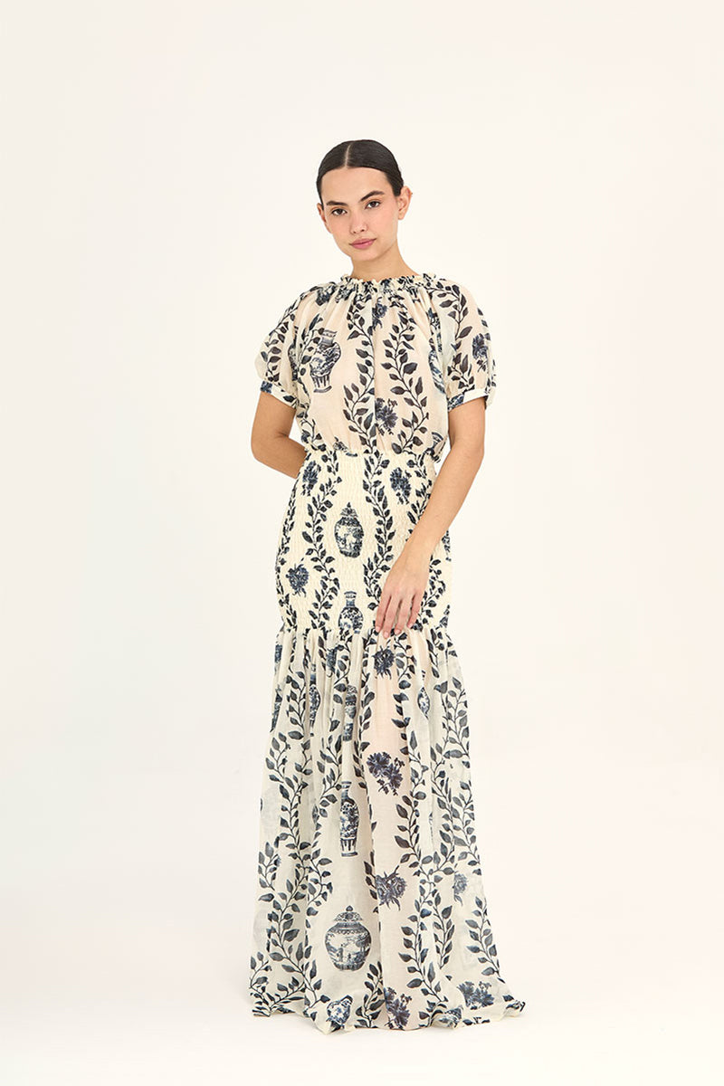 Aaguaclara Dynastie maxi dress featuring a flowing design with floral patterns in soft colors, displayed on a hanger.