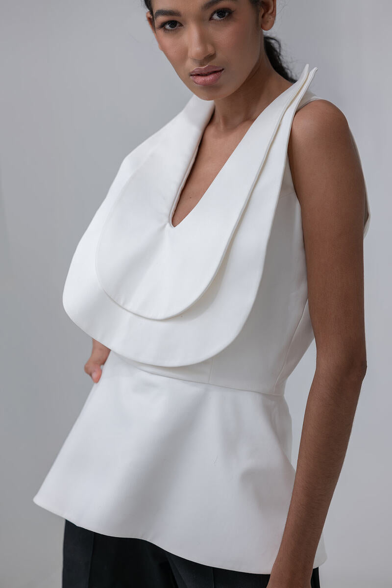 Ivory Dalia top by ANA + MARIA displayed on a hanger, featuring a soft fabric and stylish design perfect for casual wear.