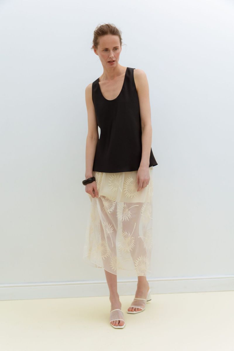 Serenity Dana black silk twill tank top displayed on a hanger, showcasing its smooth fabric and sleek design.