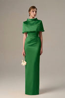 Dark green taffeta gown by I.H.F with a cropped cape and inverted lapel, featuring elegant, shiny fabric and sophisticated design.