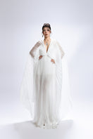 White deep V-neck pleated maxi dress by Valenciani, flowing fabric with elegant pleats, perfect for formal or summer occasions.