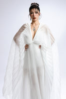 White deep V-neck pleated maxi dress by Valenciani, flowing fabric with elegant pleats and a flattering V-neckline.