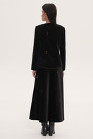 Black rose embroidered midi skirt from DELEGAN, showcasing intricate floral embroidery and a flowing, elegant design.
