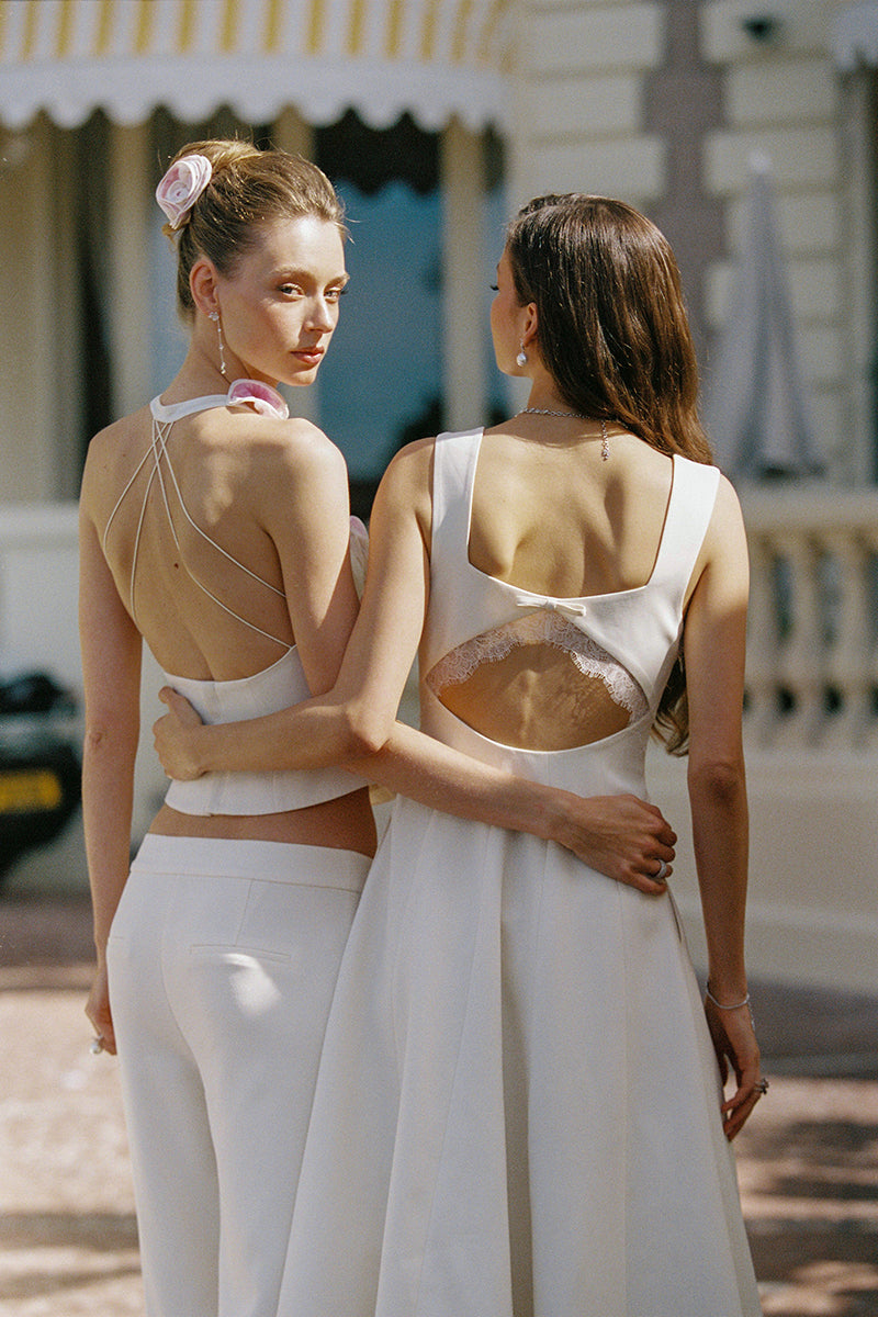 Nana Jacqueline Delilah white midi dress with cut-out design, showcased in a champagne-colored campaign setting.