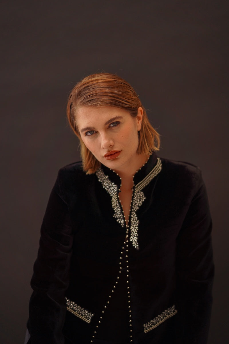 Nadya Shah Delphine velvet jacket displayed on a hanger, showcasing its luxurious deep blue velvet fabric and tailored design.