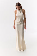 Cream silk satin halter-neck maxi dress by Serenity, featuring a flowing silhouette and elegant design.