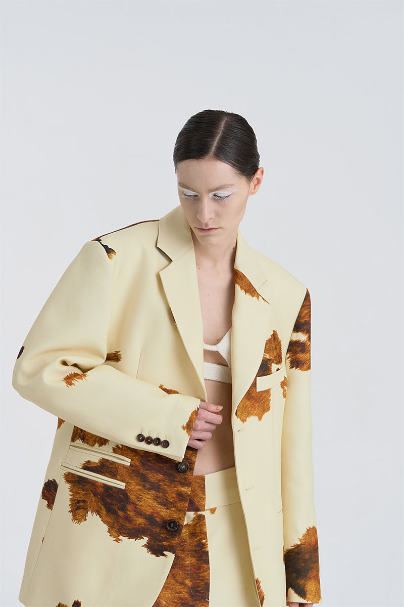 Close-up of JINSUN printed wool silk jacket in pale yellow, showcasing its textured fabric and detailed pattern.