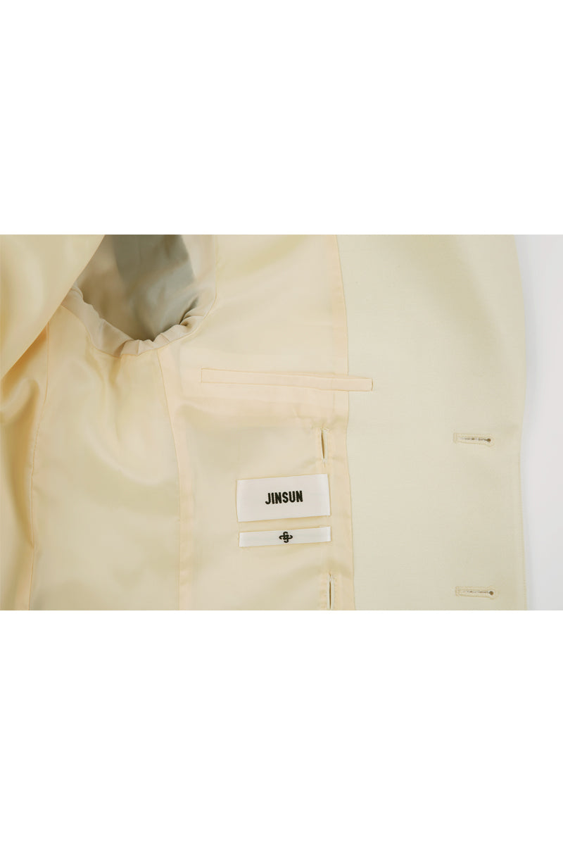 Close-up of JINSUN printed wool silk jacket in pale yellow, showcasing the fabric texture and detailed design.