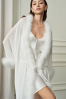 White Diva women's feather long robe by MANITO, soft and elegant, shown hanging with flowing feather details.
