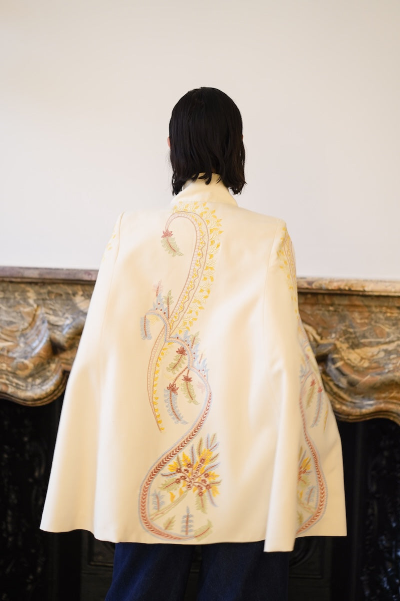 Nadya Shah Dorian Ivory Cape jacket shown from the back, featuring elegant flowing fabric and detailed design.