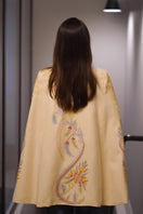 Nadya Shah Dorian ivory cape jacket displayed from the back, showcasing its elegant drape and stylish design.