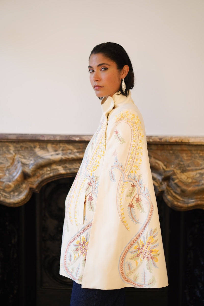 Nadya Shah Dorian ivory cape jacket shown draped over a mannequin, featuring elegant fabric and stylish design.