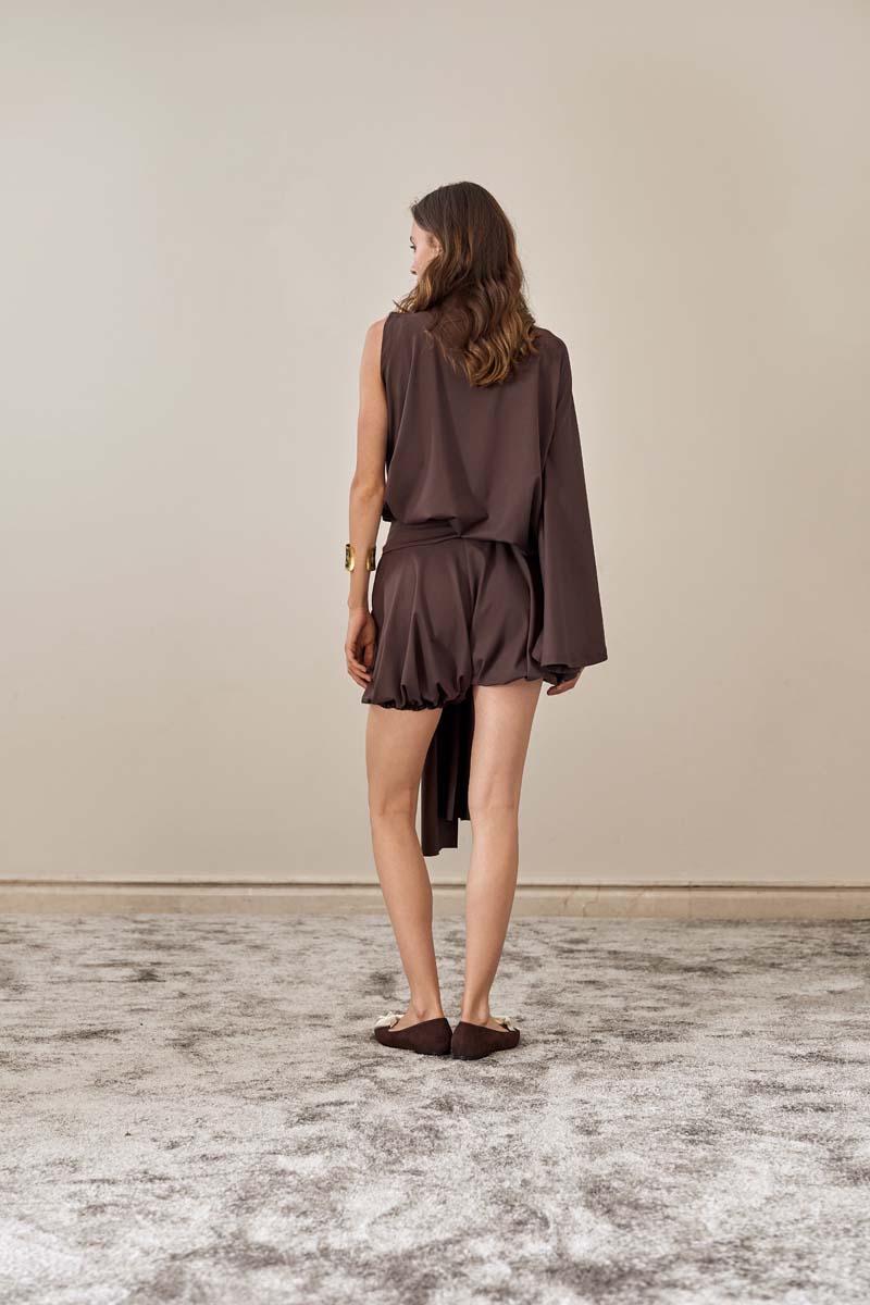 Back view of brown Drift shorts by YASSMIN SALEH, showcasing relaxed fit and stylish design for casual wear.