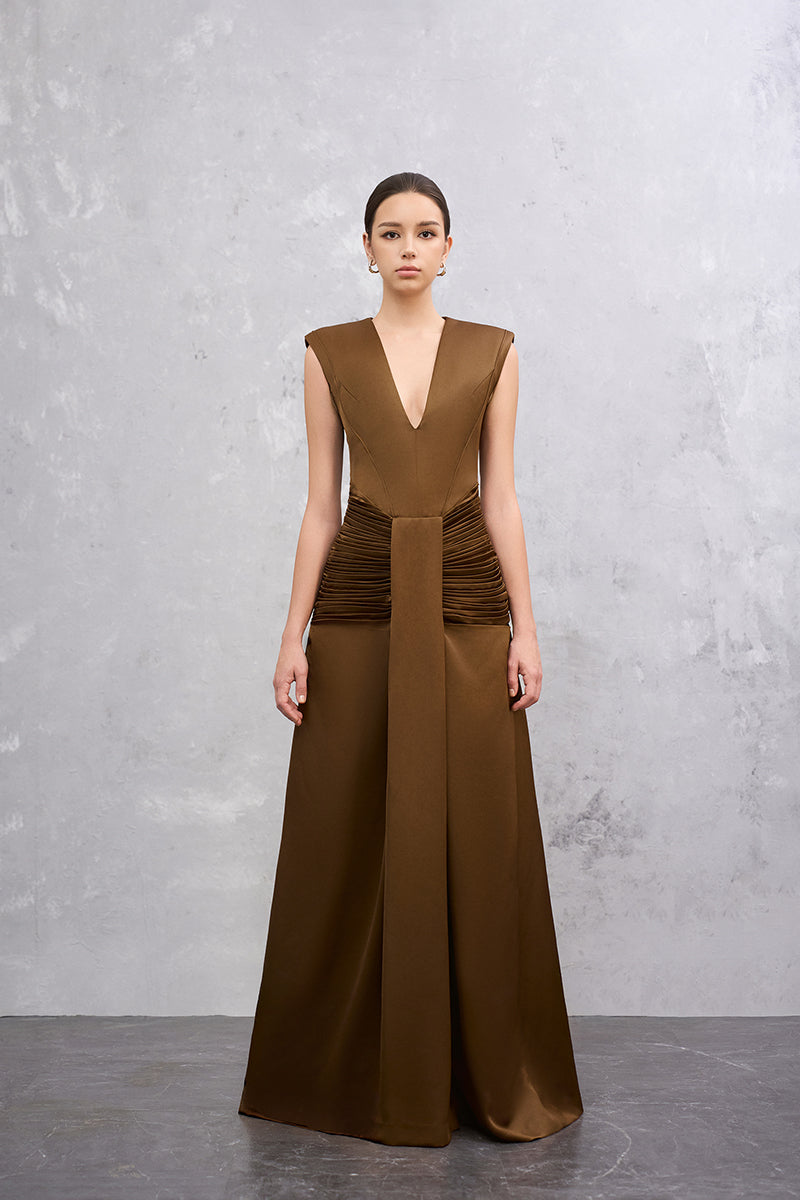 Brown AIRA gown by EEGEN STUDIO, elegant dress with flowing fabric and intricate design, shown on a dress form.
