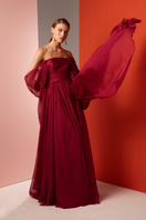 Red strapless gown by Joanna Andraos featuring elegant draping and a fitted bodice, suitable for formal occasions.