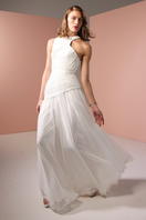White asymmetrical low waistline gown by Joanna Andraos, featuring elegant draping and modern design details.