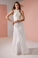 White asymmetrical low waistline gown by Joanna Andraos, featuring elegant draping and a modern silhouette.