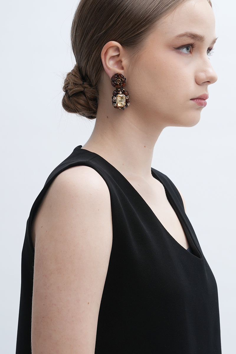 Gold Amora earrings by Aidan & Ice featuring elegant, shiny gold earrings with intricate design details.