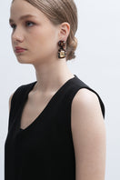 Gold Amora earrings by Aidan & Ice featuring elegant gold hoop design with intricate detailing, displayed on a neutral background.