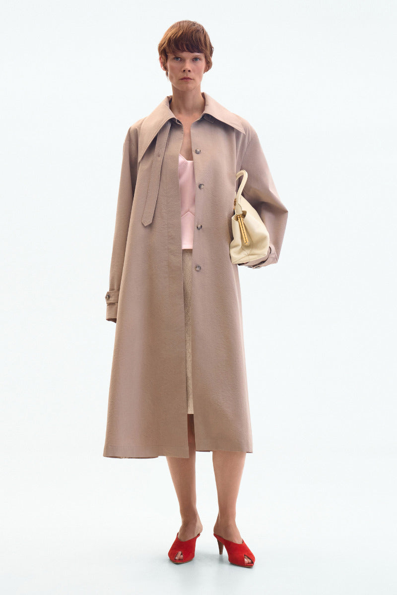 ELENAREVA taupe oversized trench coat displayed on a hanger, showcasing its classic design and lightweight fabric.