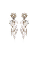 A pair of white Aidan & Ice Neilla earrings with a sleek, minimalist design hanging against a neutral background.