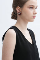 A pair of Peach Greta earrings by Aidan & Ice featuring elegant peach-colored dangle earrings with gold accents.