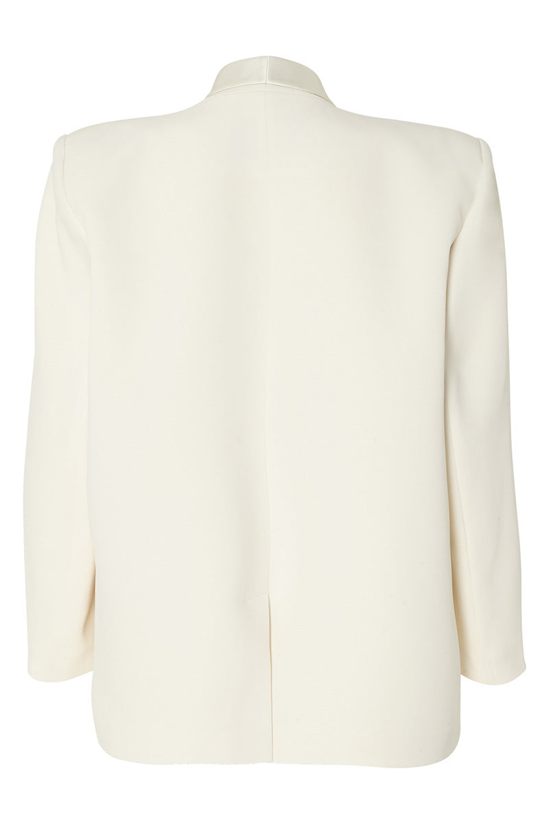 Studio NK ETHERAL blazer in ivory, stylish tailored blazer with a sleek fit, displayed on a model with a plain background.