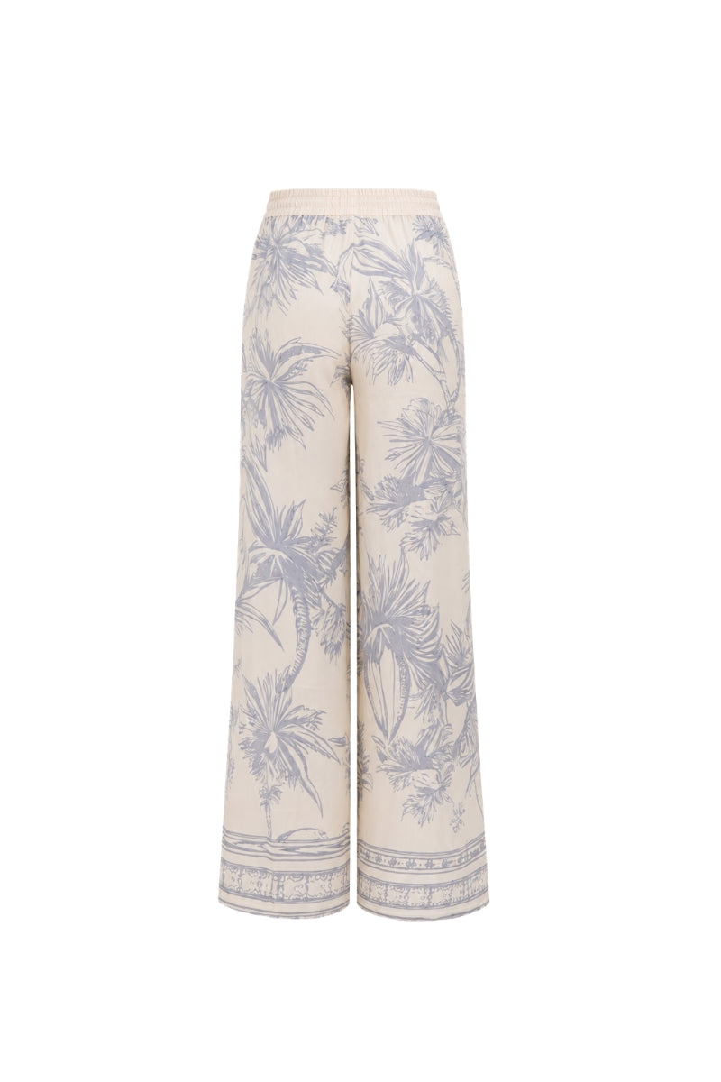 White printed EZMIR pants by Tinta Latina, stylish casual pants with vibrant design, shown laid flat on a white background.