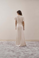 Back view of YASSMIN SALEH ivory maxi dress from the EASE collection, featuring flowing fabric and elegant design.