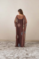 Back view of YASSMIN SALEH brown echo maxi dress with flowing fabric and elegant design.
