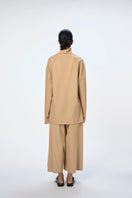 Cream-colored URA EIRA TOP made of soft fabric, featuring a relaxed fit and stylish neckline, perfect for casual wear.