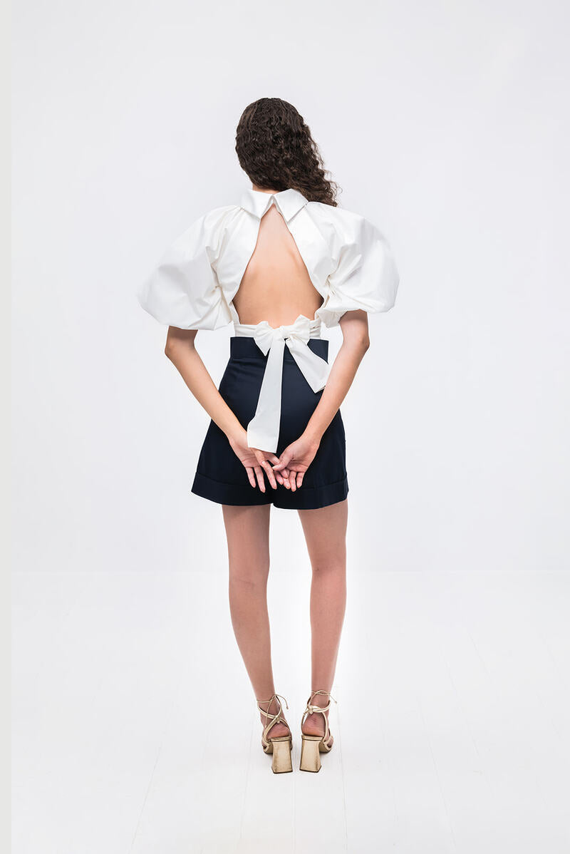 Ivory Elara crop top by ANA + MARIA displayed on a hanger, showing its fitted style and soft fabric.