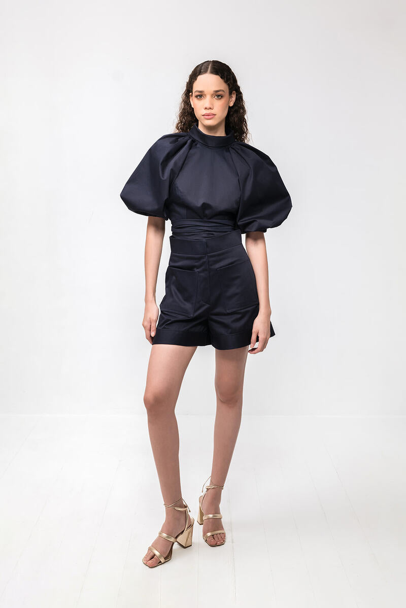 Navy blue Elara crop top by ANA + MARIA featuring a fitted style and short sleeves, shown on a model.