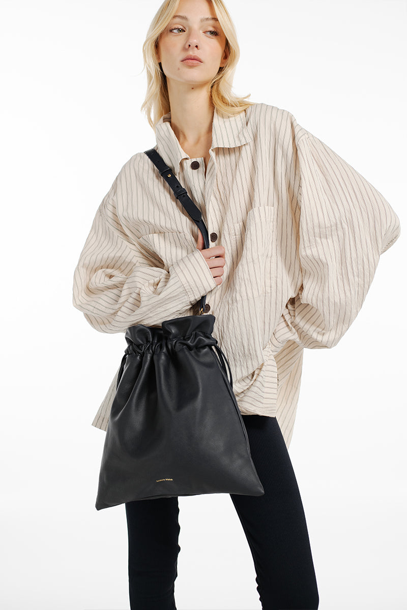 Black ISIDORA MALVA Elena pouch with top handle, featuring a sleek, compact design and minimalist style.