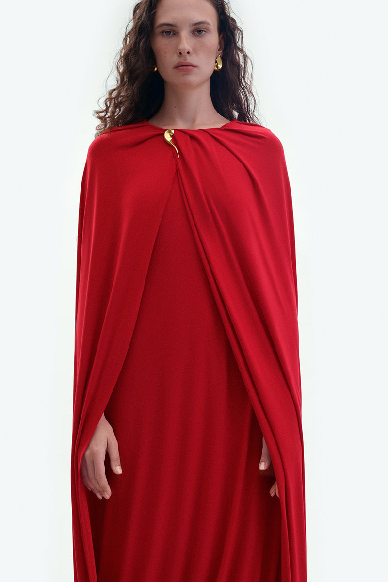 Red jersey midi cape dress by ElenaReva, featuring a flowing design and stylish cape detail, perfect for elegant occasions.