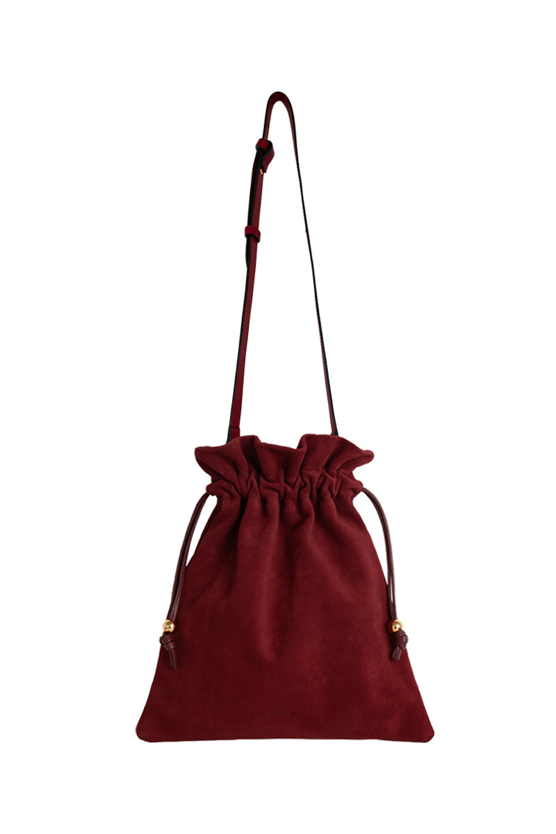 ISIDORA MALVA Elena suede pouch in burgundy with a top handle, showcasing its elegant design and soft suede texture.