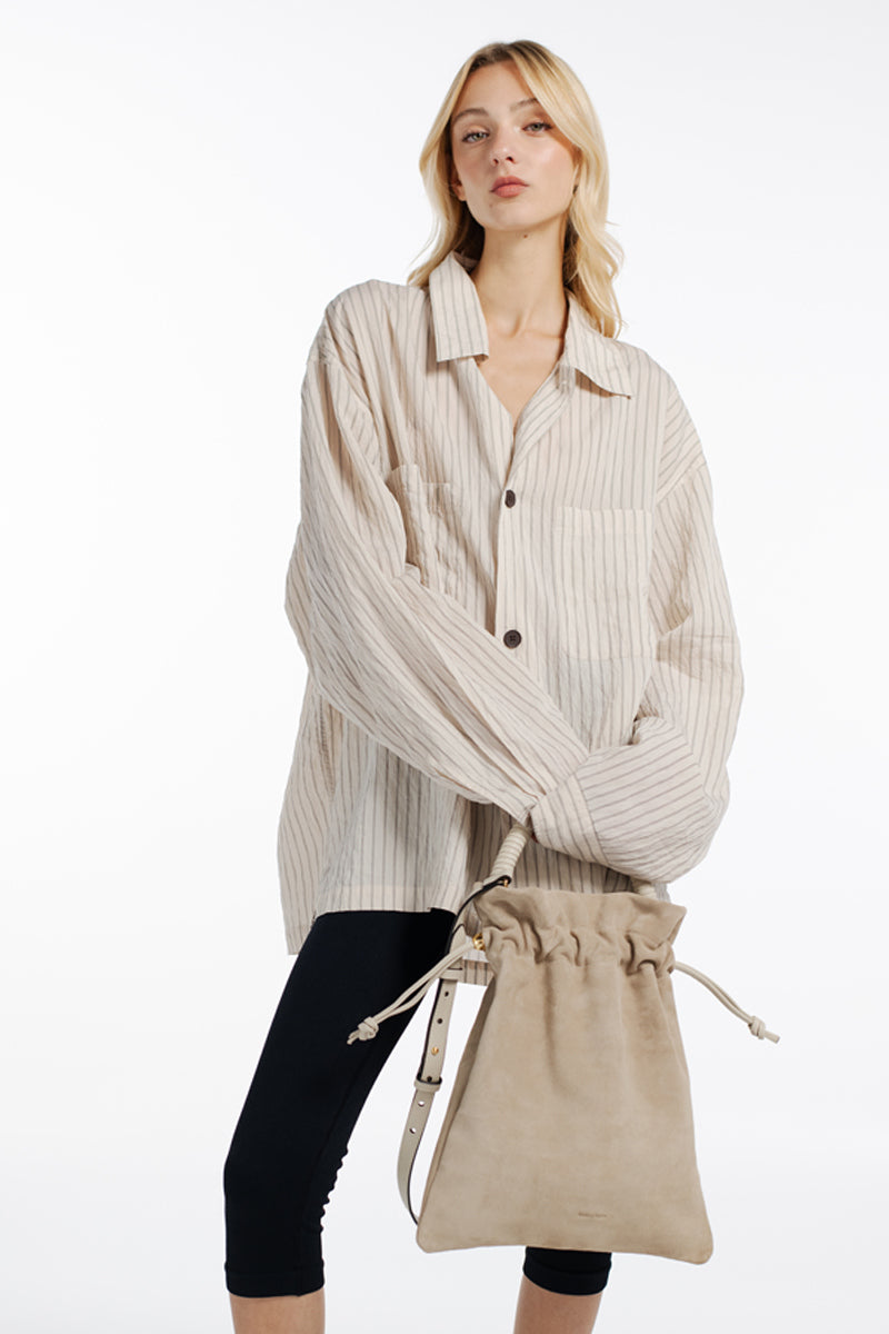 ISIDORA MALVA Elena suede pouch in nude, top handle bag with sleek design and soft suede texture, ideal for elegant everyday use.