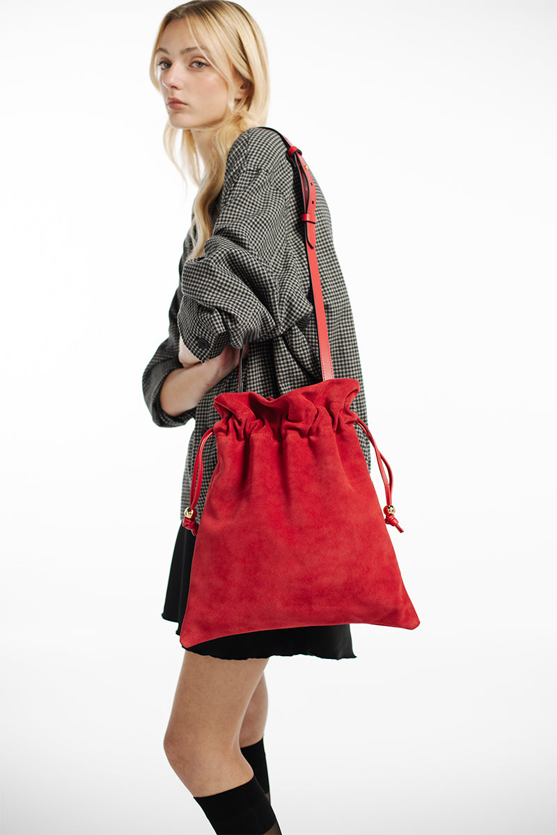 Red suede Elena pouch by Isidora Malva, a stylish top handle bag with elegant design and compact size.