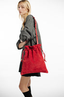 Red suede Elena pouch by Isidora Malva, a stylish top handle bag with elegant design and compact size.