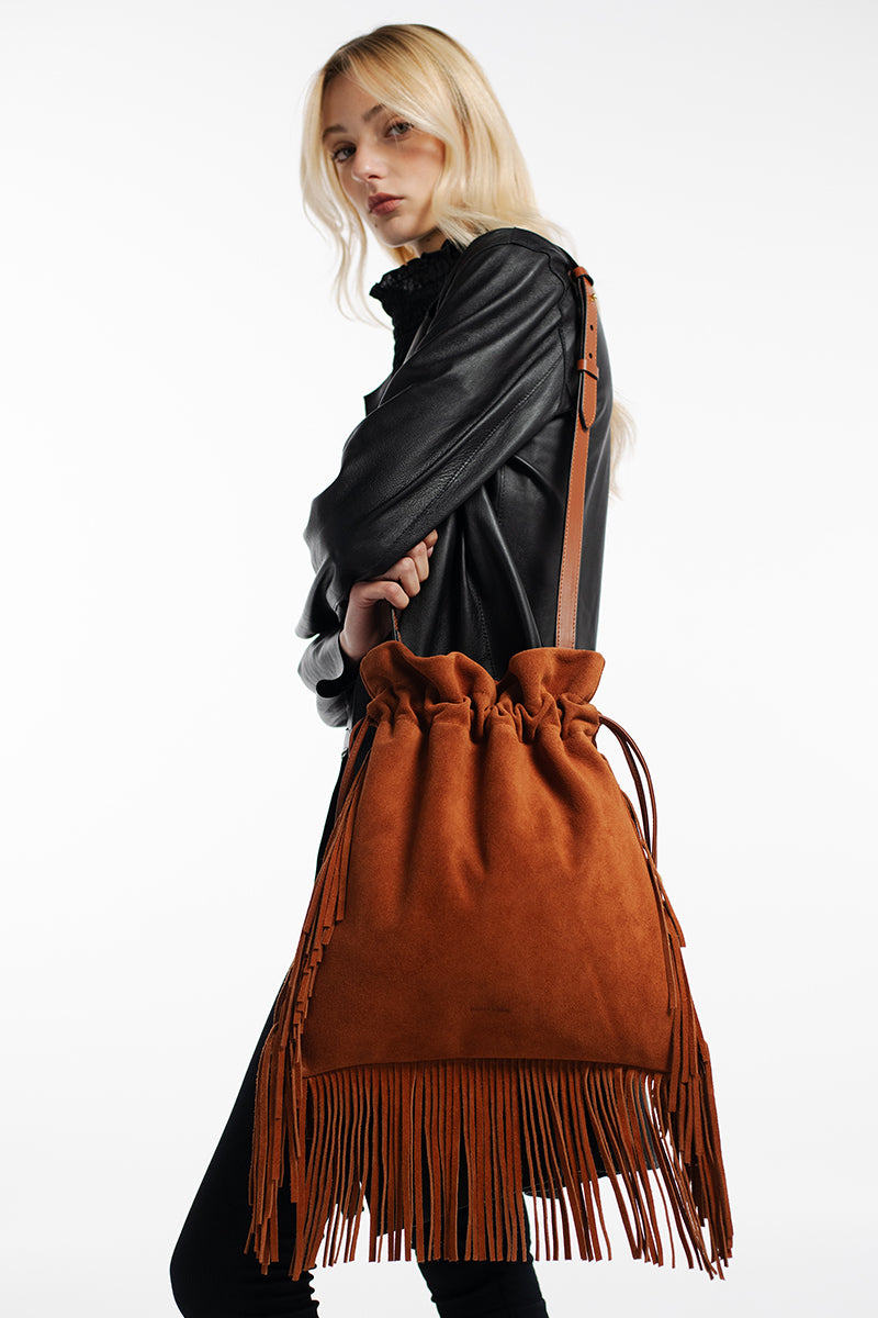 Tan suede top handle bag with fringes by ISIDORA MALVA, featuring a stylish design and elegant craftsmanship.