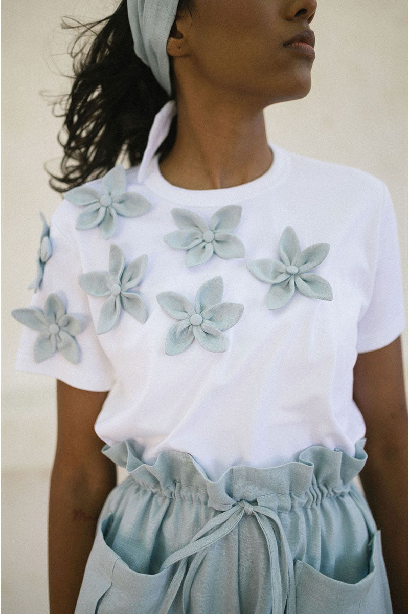 Light blue ANA + MARIA Elia T-shirt featuring a classic crew neck and short sleeves, displayed on a plain background.