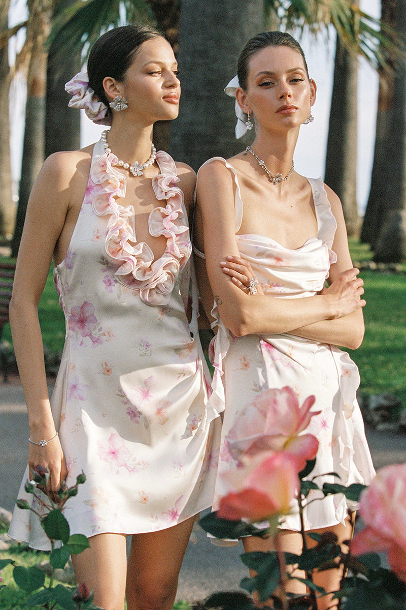 Nana Jacqueline Ella floral mini dress with ruffle halter neckline in beige, shown on a model in a campaign setting.