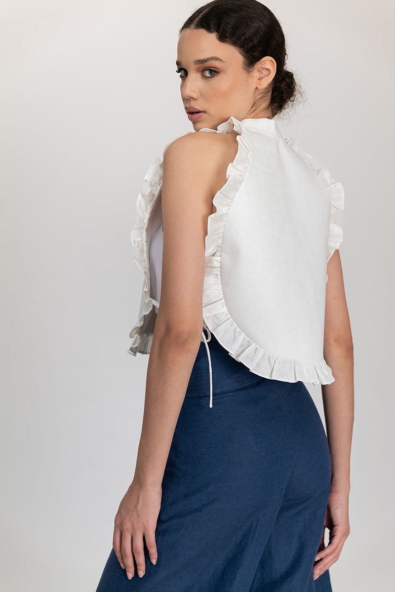 Cream-colored Ellen Bib top by ANA + MARIA featuring a stylish bib design, displayed on a neutral background.